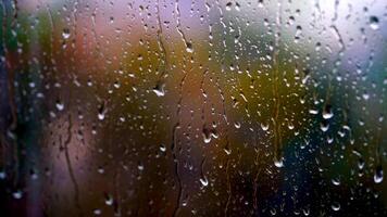 Heavy rain falling outside the window. Big drops moving down on glass background. Texture of flowing droplets on window. Close-up. video