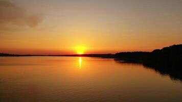 Beautiful sunset over the river. Amazing landscape of the evening water with the golden path from the setting sun. Wonderful lake at sunset. Motion camera to the left. video