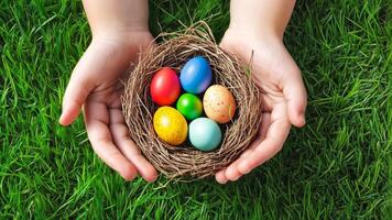 A childs hands next to an Easter basket with colorful eggs, set on lush green grass. video