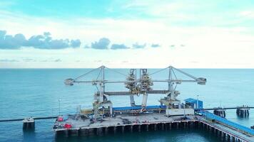 An aerial shot showcasing a state-of-the-art bulk material handling system at a busy coastal port. The image captures the scale and efficiency of modern maritime operations. video