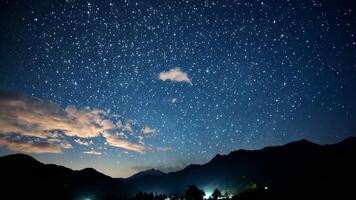 Starry night sky shining over mountain range with clouds video