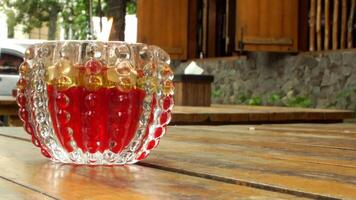a glass with red liquid sitting on a wooden table video
