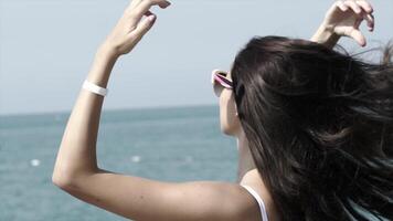 Beautiful girl enjoys the sun on the background of the sea video