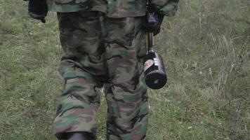 Paintball player walking through the forest in slow motion video