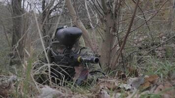 Paintball player in grass aiming in slow motion video