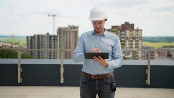 Construction engineer using tablet for project management on rooftop site video