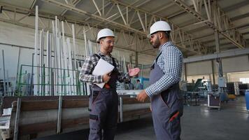 handslag två olika ingenjörer på de bakgrund av en fönster fabrik video