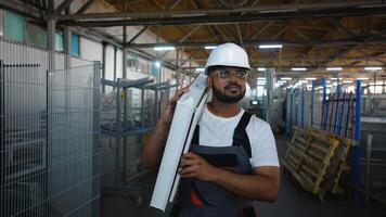 indisk arbetstagare promenader med en fönster ram i en fönster fabrik nära transportband video