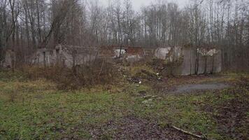 An old, abandoned building, forgotten and surrounded by tall grass and trees, exudes a gloomy atmosphere video