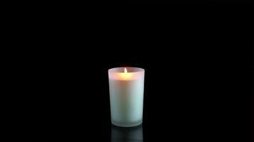 White candle is extinguished on a black background video