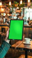 Tablet computer with green screen in cafe. Chroma key. photo