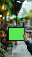 Blank green screen on tablet pc in coffee shop, stock photo
