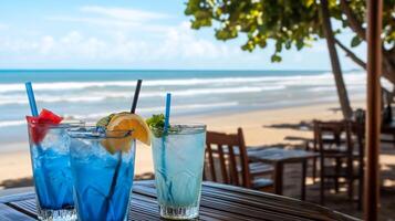Refreshing colorful drinks on a beachside table with ocean view. photo