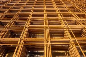 Rusty rebar grid used in construction for reinforcing concrete structures, showcasing the intricate pattern and texture of the steel bars photo