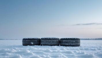 Winter tires on the snow in the field on sky background. photo