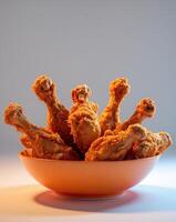 Delicious Crispy Fried Chicken Drumsticks in an Orange Bowl.Delicious Crispy Fried Chicken Drumsticks in an Orange Bowl. photo