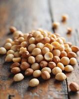 Pile of Roasted Macadamia Nuts on a Wooden Table.Pile of Roasted Macadamia Nuts on a Wooden Table. photo