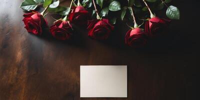 Blank mock up card on the table decorated with red rosesBlank mock up card on the table decorated with red roses. photo