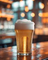 Frosty beer glass with rich foam on a bar table with warm ambient lighting in the background photo