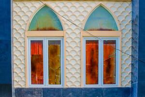 a window with two arched windows and a blue wall photo