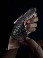 Indonesian Rupiah bills arranged on a dark surface showing 100000 denominations photo
