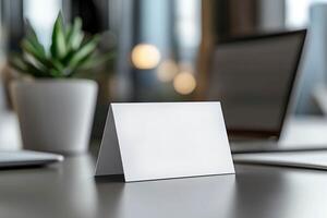 Clean business card mockup on a sleek table surrounded by contemporary office elements in a well-lit workspace. photo