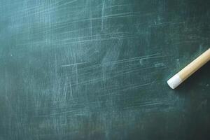 Close-up of a clean chalkboard with a piece of chalk resting on its surface in a classroom setting photo