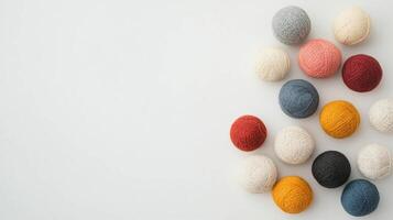 Colorful balls of wool in various shades arranged neatly on white background, copy space photo