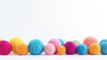 Colorful balls of wool arranged on a white background create a vibrant display of crafting materials photo