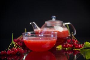 nutritious tea from viburnum berries, isolated on black background photo