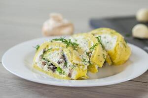 Vegetarian food. baked potato roll with cottage cheese filling with garlic and mushrooms, on a light wooden table photo