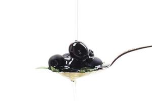 black olives in a spoon isolated on a white background photo