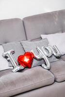 I love you from balloon setting on grey sofa. Theme of love. photo