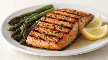 Healthy Food Revolution, Grilled salmon filet with a side of roasted asparagus and lemon wedges photo