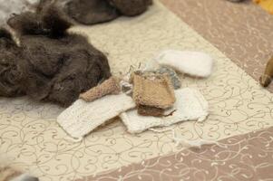 Wool and hand-knitted fabric samples on a patterned surface photo