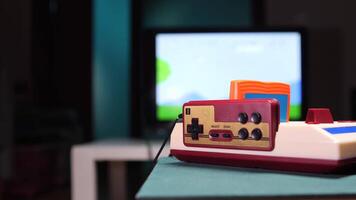 Gamer inserting controller into retro game console. Retro game console displaying pixel art video