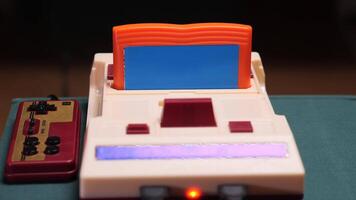 Retro game cartridge being inserted into console with controller video