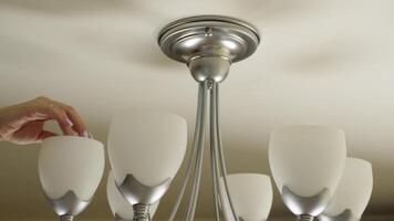 Hand adjusting contemporary ceiling light fixture for optimal illumination video