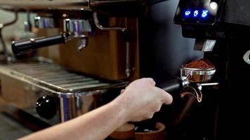 Professional grinder in action, barista focusing on quality coffee-making, close-up of espresso preparation, precise movements, and dedication to crafting perfect coffee. video