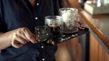 Serving coffee espresso with ice cream and with flavored doping syrup in transparent cups on tray in modern setting of cozy cafe showcasing barista craftsmanship, Turkey, Alanya, July 16, 2024. video