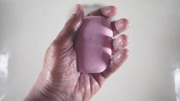 A Hand Gently Holding a Pink Soap Under Water, Creating Bubbles Around It video