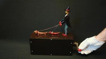 tall gentleman in black tailcoat and hat, red shoes on a walk with two dachshunds, man turn handle, close-up, automaton with sound video