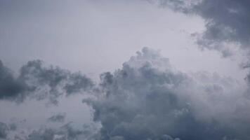 Clusters of gray rain clouds moving slowly across a hazy sky, reflecting the turbulent weather during Thailand's rainy season. video