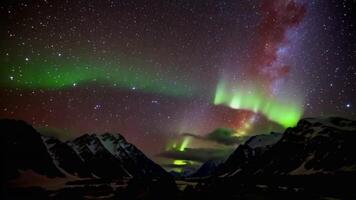 captivating aurora borealis dances over snowy mountains at night in the Arctic wilderness video