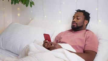 black man using smartphone after waking up, internet addiction problem of modern people video