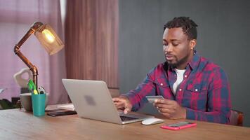 shopping online, black man inputting credit card data on site, playing online, internet fraud video