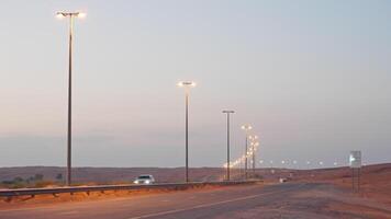 large car road in desert in UAE in evening, automobiles moving on highway with illumination video