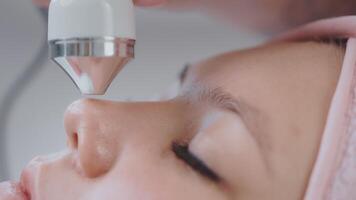 sonophoresis and facial massage of young female patient in beauty clinic, closeup view of face video