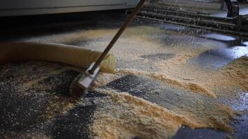 Sawdust Sweeping in Workshop with Hose and Machinery in Background video