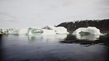 Majestic iceberg formations floating in calm Arctic waters near Greenland video